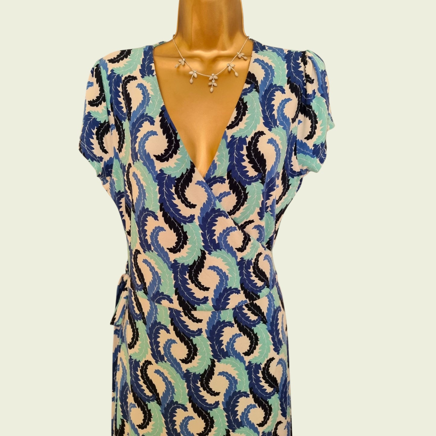 Mannequin wearing a patterned dress with a white background