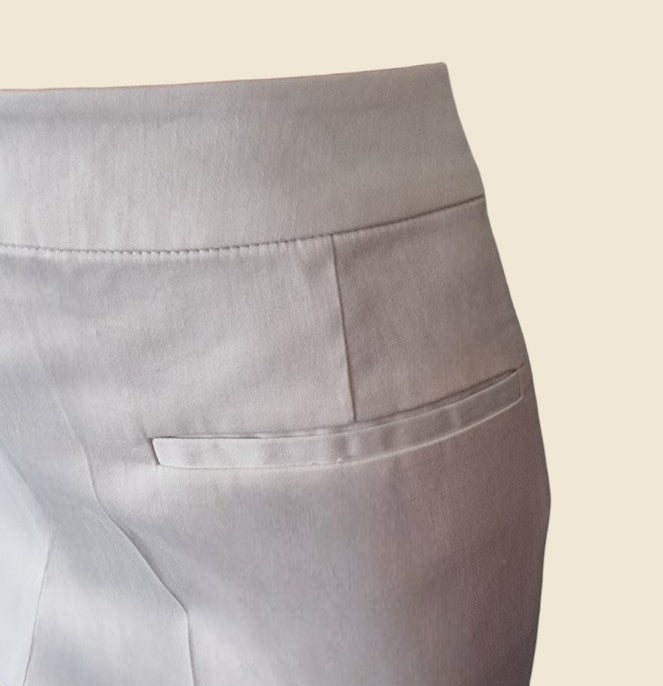 Close-up of white pants with a pocket on a beige background