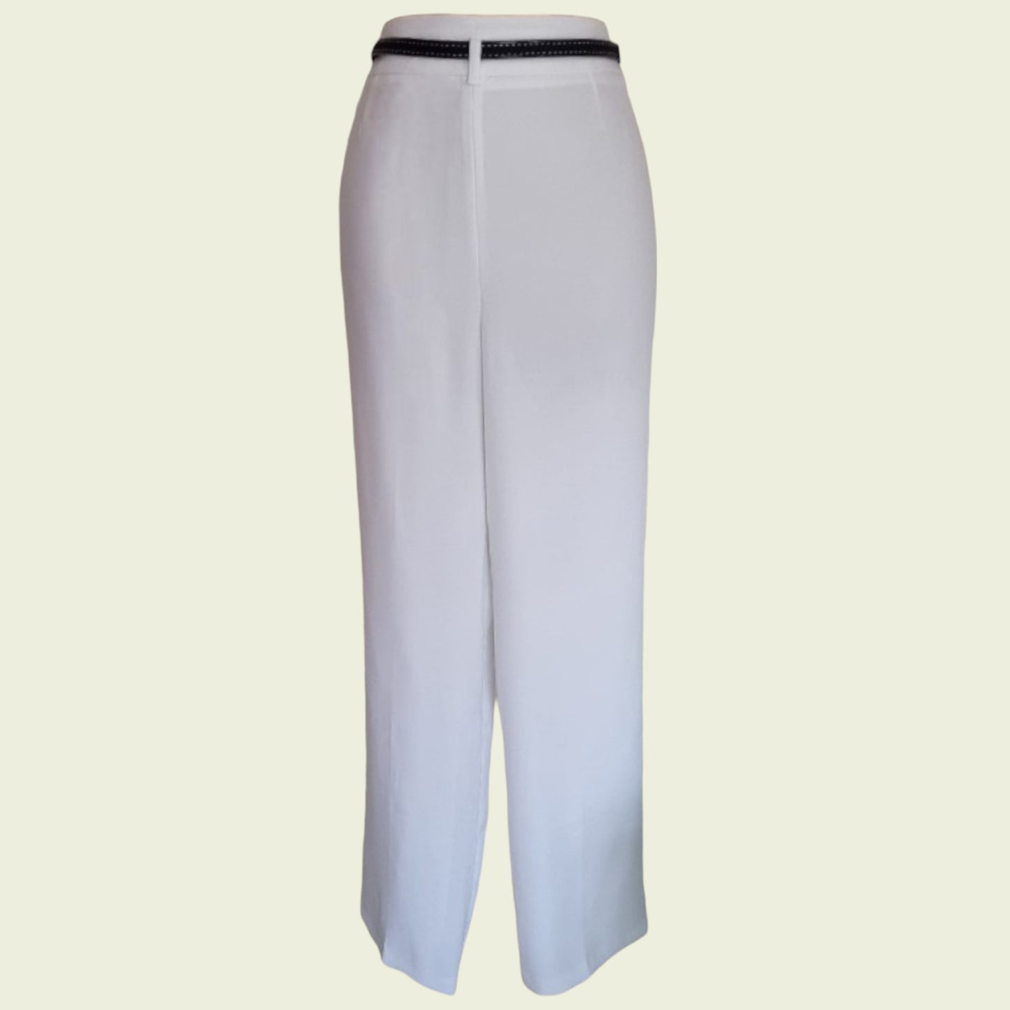 White pants with a navy belt on a beige background