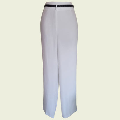 White pants with a navy belt on a beige background