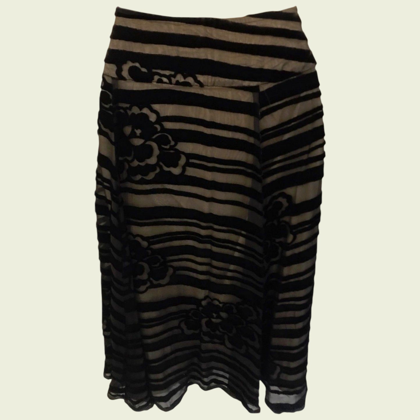 Black and brown striped skirt with floral patterns on a beige background