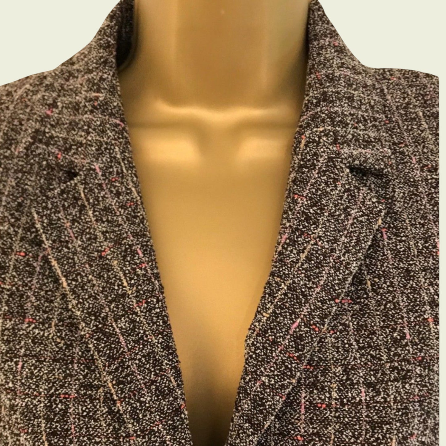 Mannequin wearing a coat with a neutral background