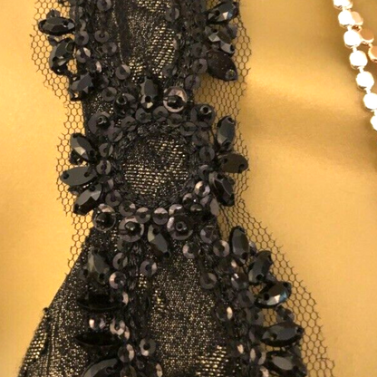 Close-up of a black beaded fabric on a gold background