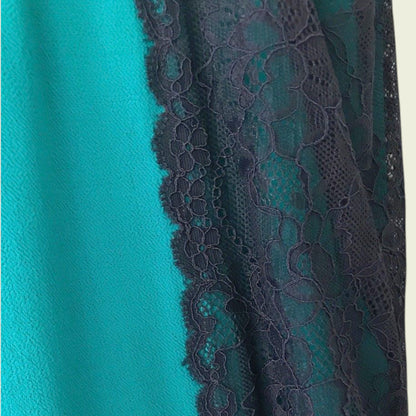 Teal fabric with lace trim on a beige background