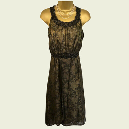 Black lace dress on a mannequin against a beige background