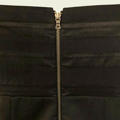 Close-up of a black jacket with a zipper on a beige background