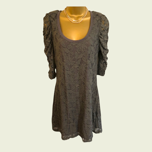 Dark lace dress on a mannequin against a plain background