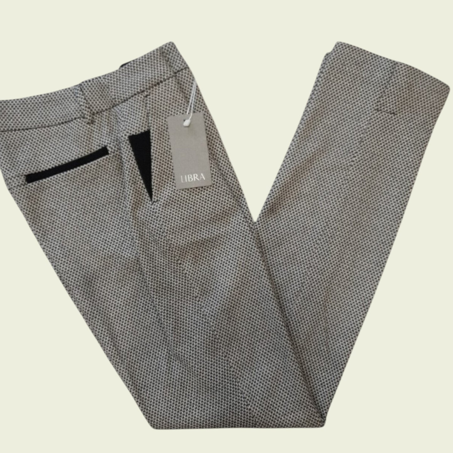 Gray patterned pants with a tag on a beige background