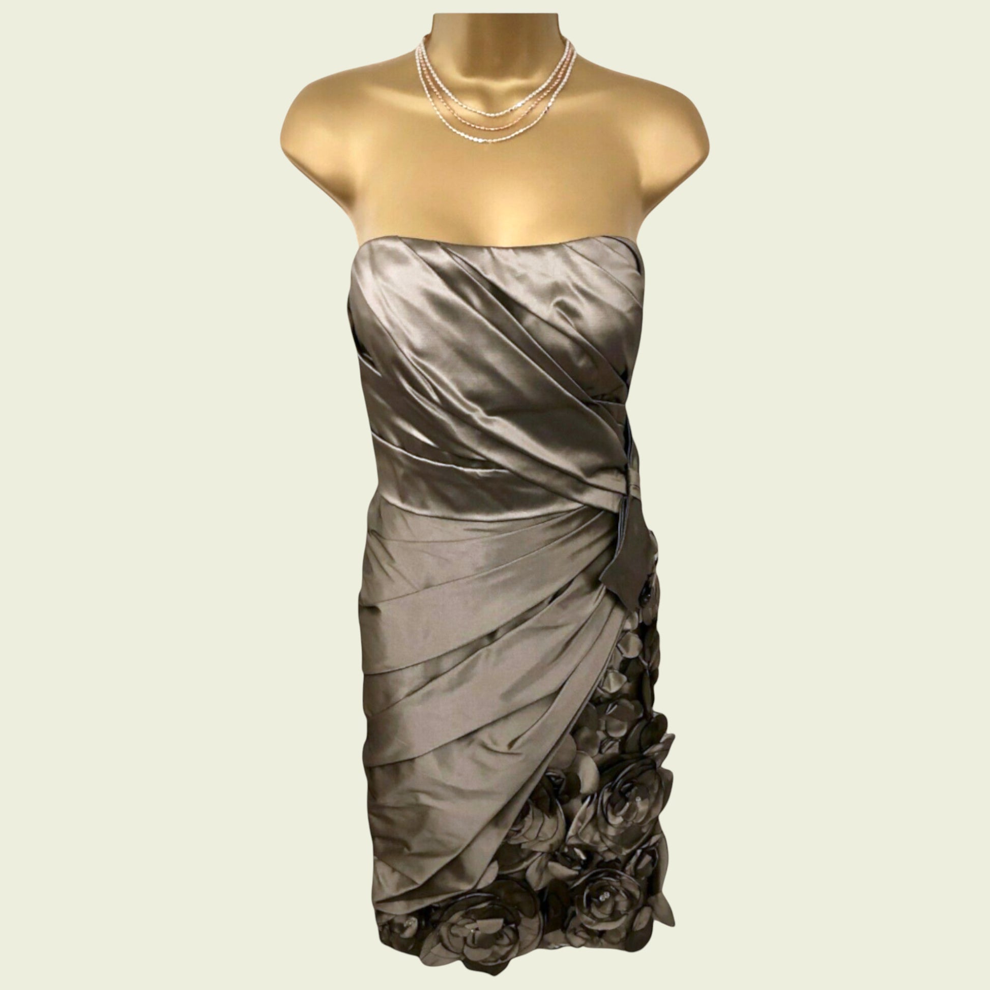 Mannequin wearing a gray strapless dress with floral details on a beige background