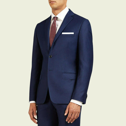 Navy blue suit with a white shirt and patterned tie on a beige background