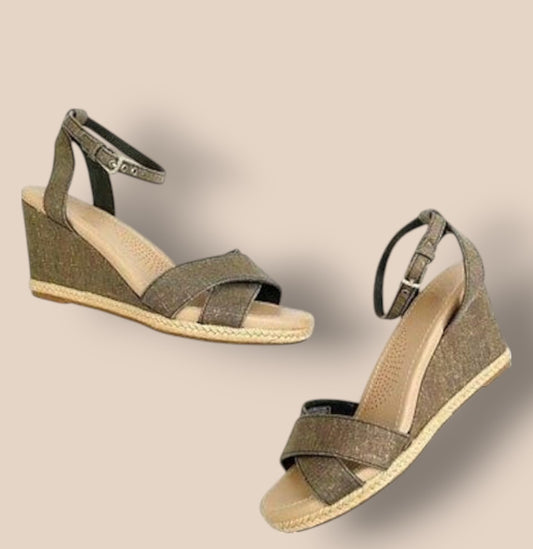 Pair of green wedge sandals on a beige background