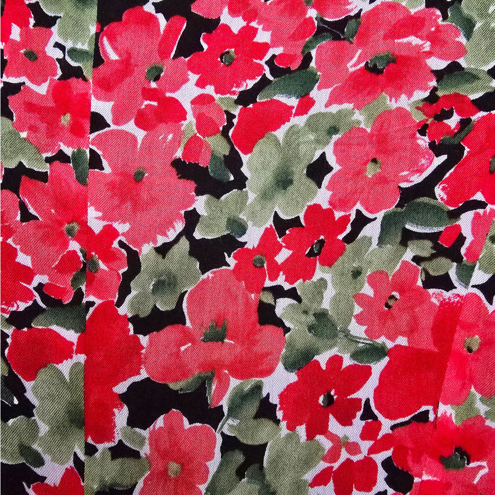 Floral pattern with red, green, and black flowers on a fabric background.