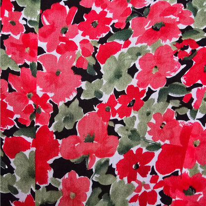 Floral pattern with red, green, and black flowers on a fabric background.