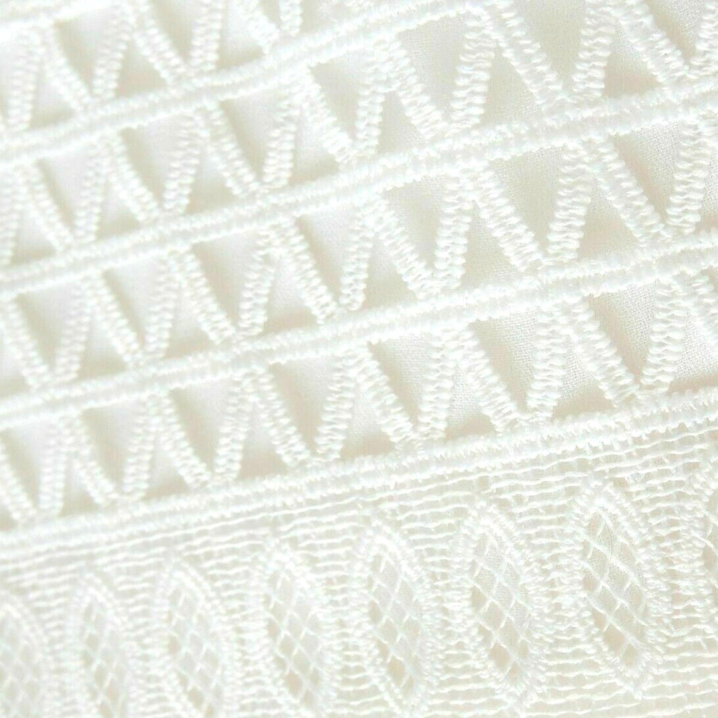 Close-up of a textured white fabric with a diamond pattern