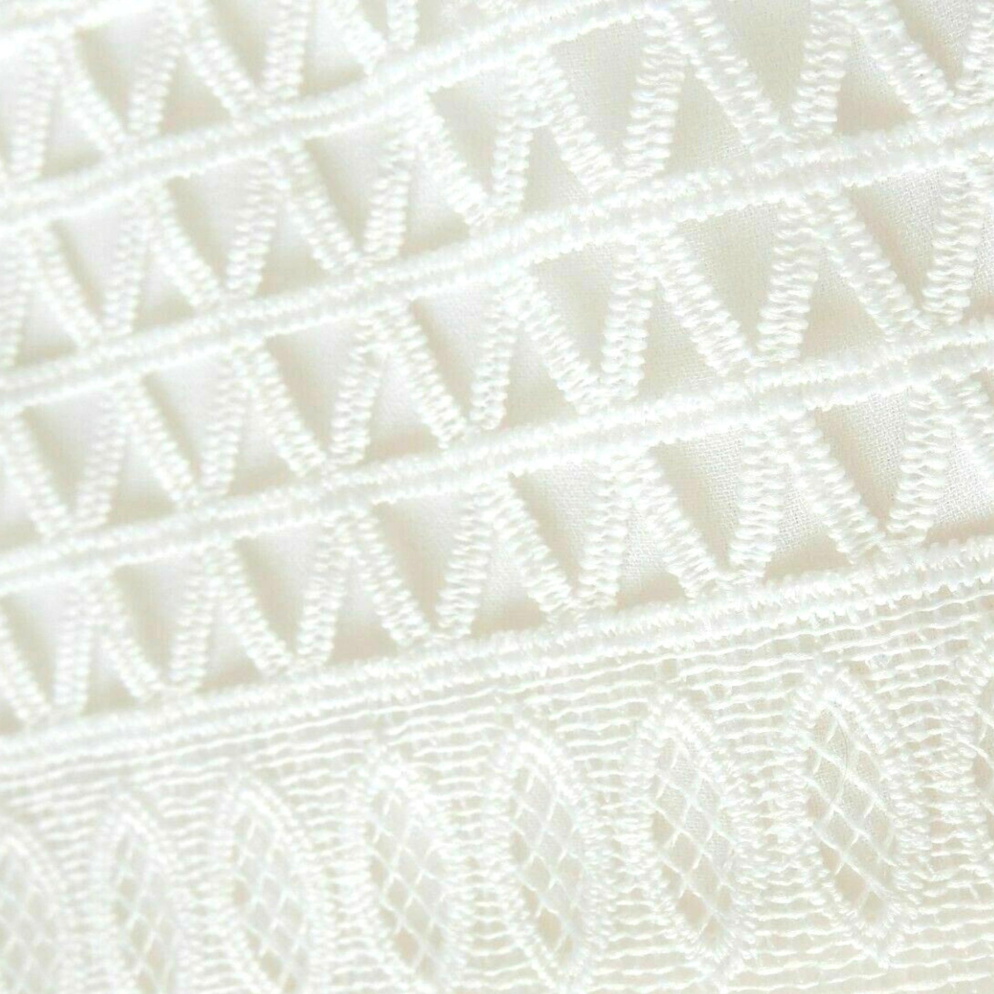 Close-up of a textured white fabric with a diamond pattern