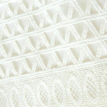 Close-up of a textured white fabric with a diamond pattern
