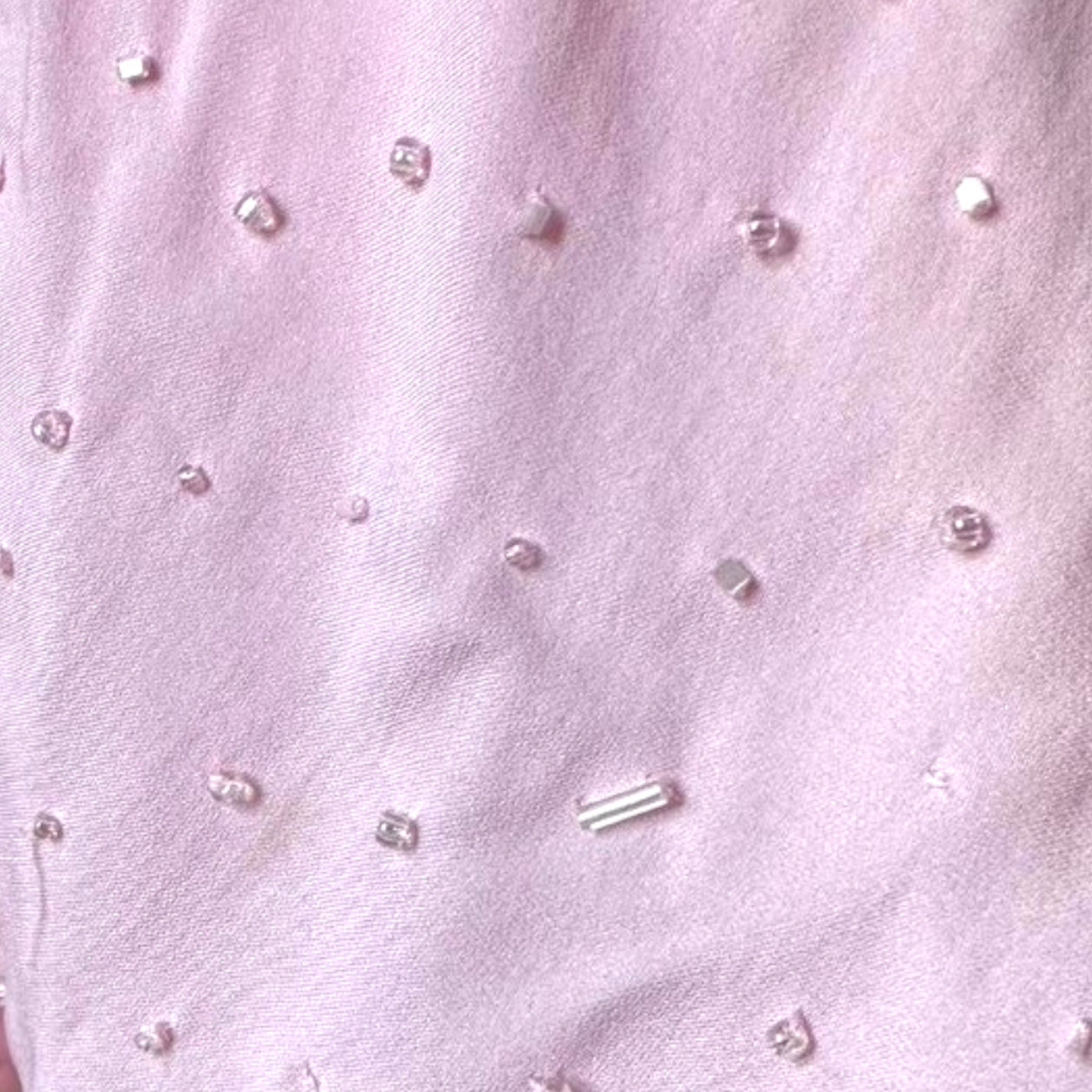 Close-up of pink fabric with small decorative beads.