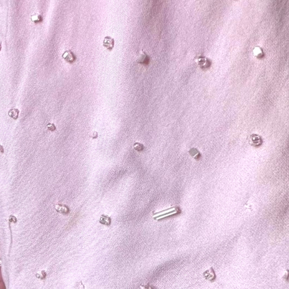 Close-up of pink fabric with small decorative beads.