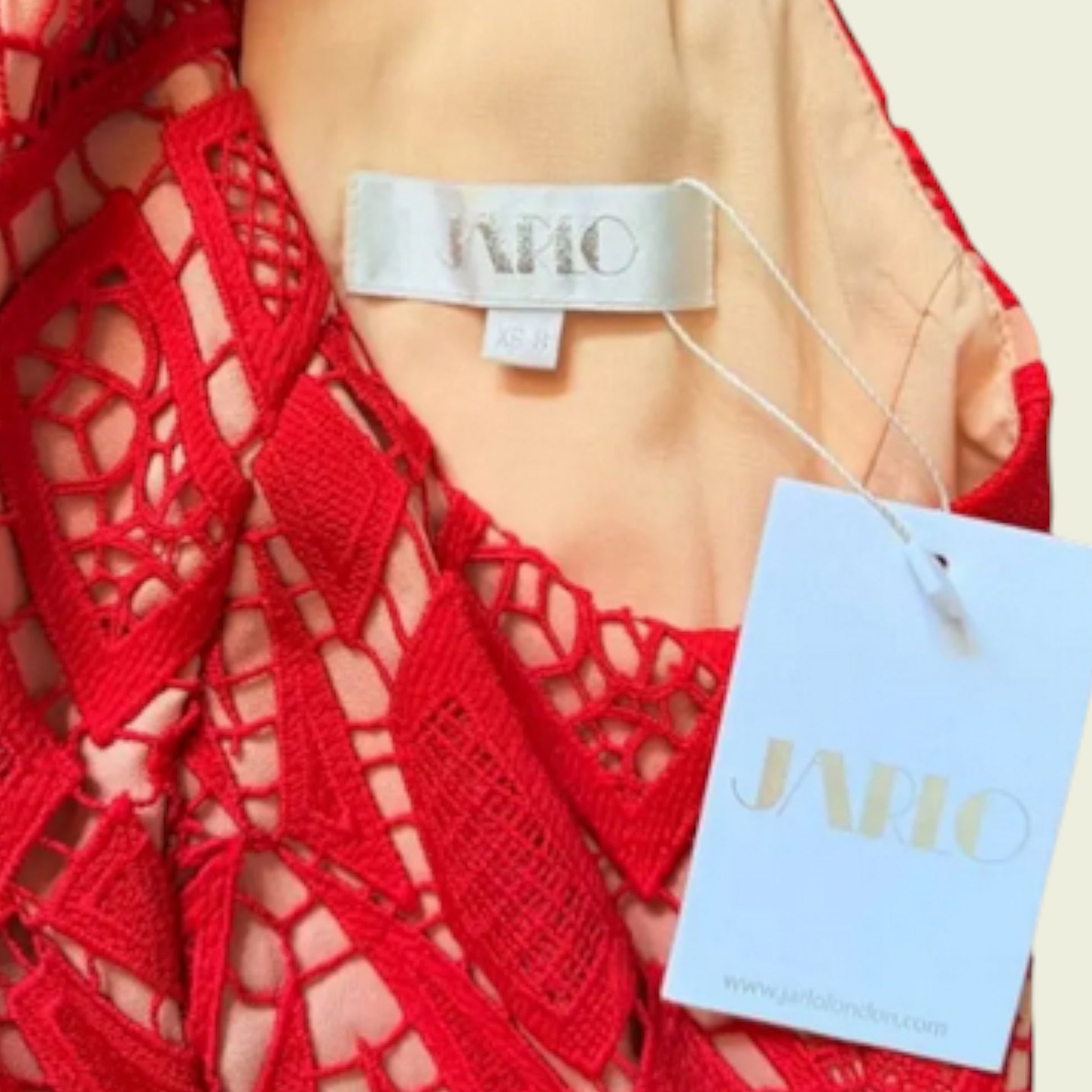 Red lace garment with 'JARLO' brand tag on a beige background