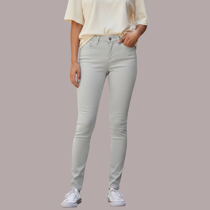 Person wearing light gray jeans and a cream top on a plain background