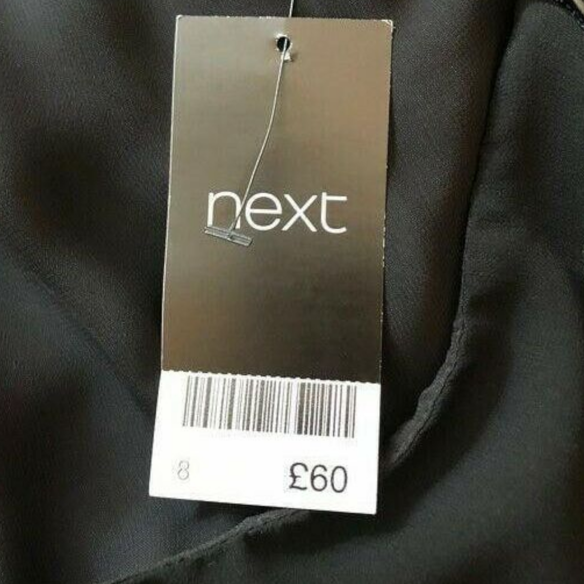 Black garment with a 'next' brand tag showing price £60