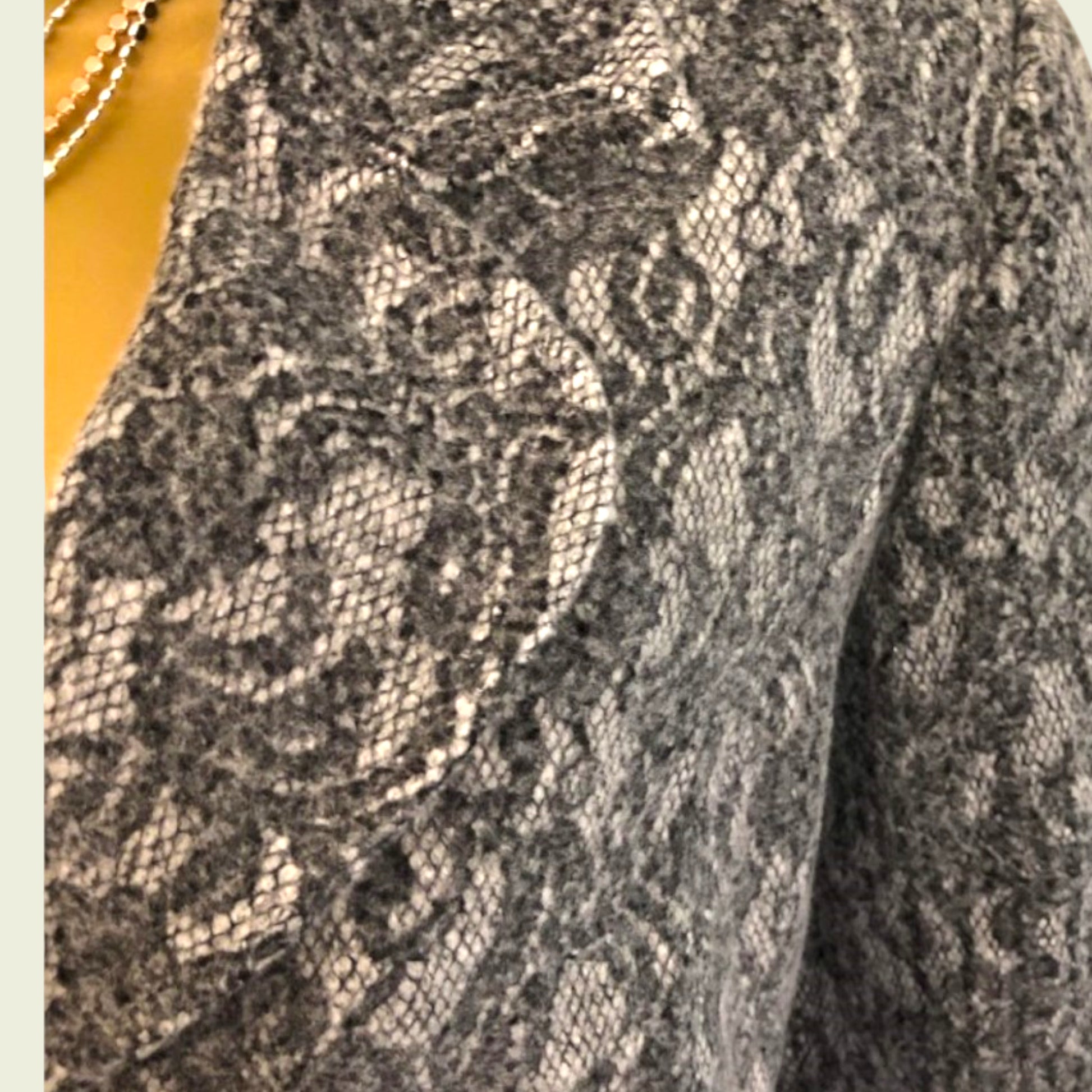 Close-up of a textured fabric with a pattern, possibly a sweater or coat.