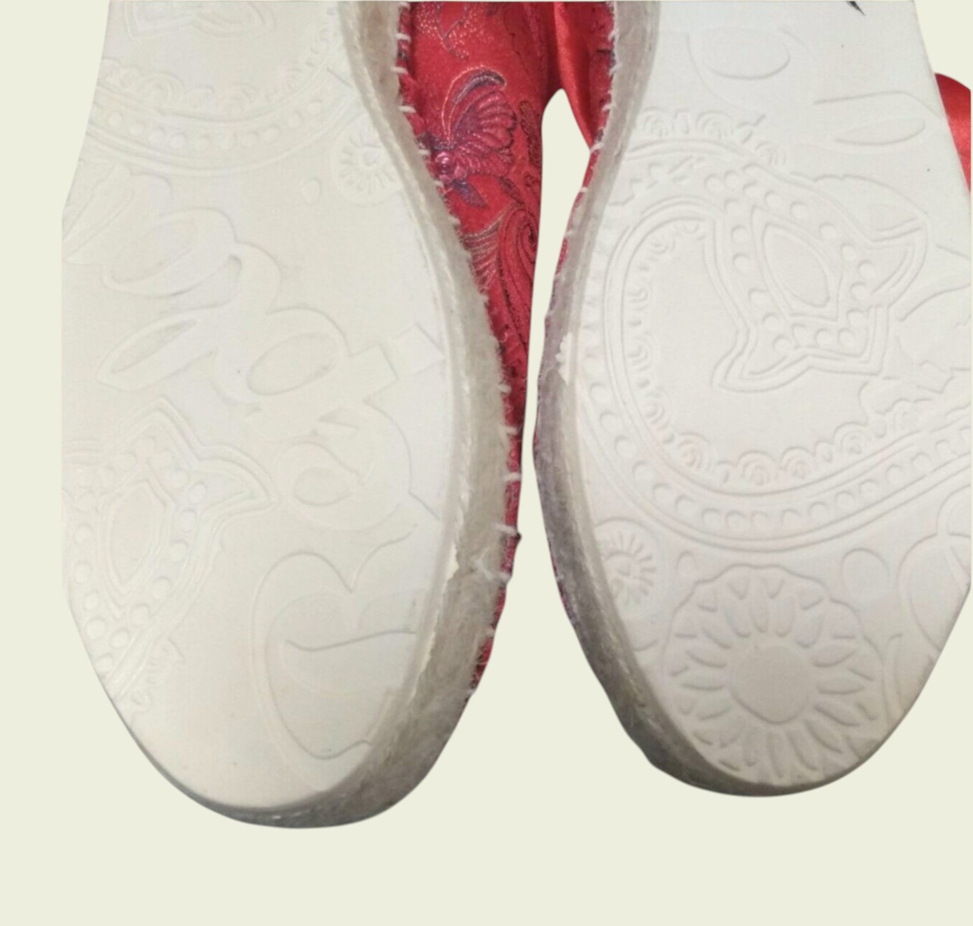 Red shoes showing white sole on a light gray background