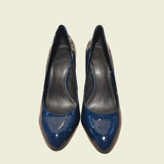 Pair of blue high-heeled shoes on a light beige background