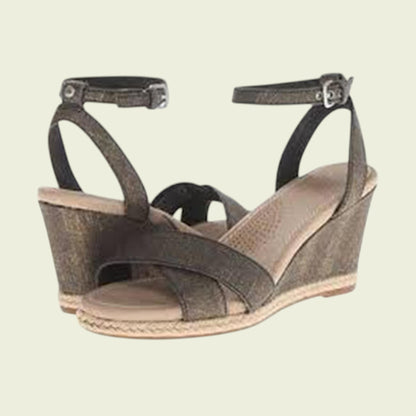 Brown wedge sandal with ankle strap on a beige background