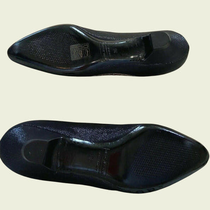 Two black shoe insoles on a beige background