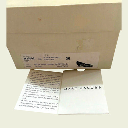 Marc Jacobs shoe box with a card inside on a light background