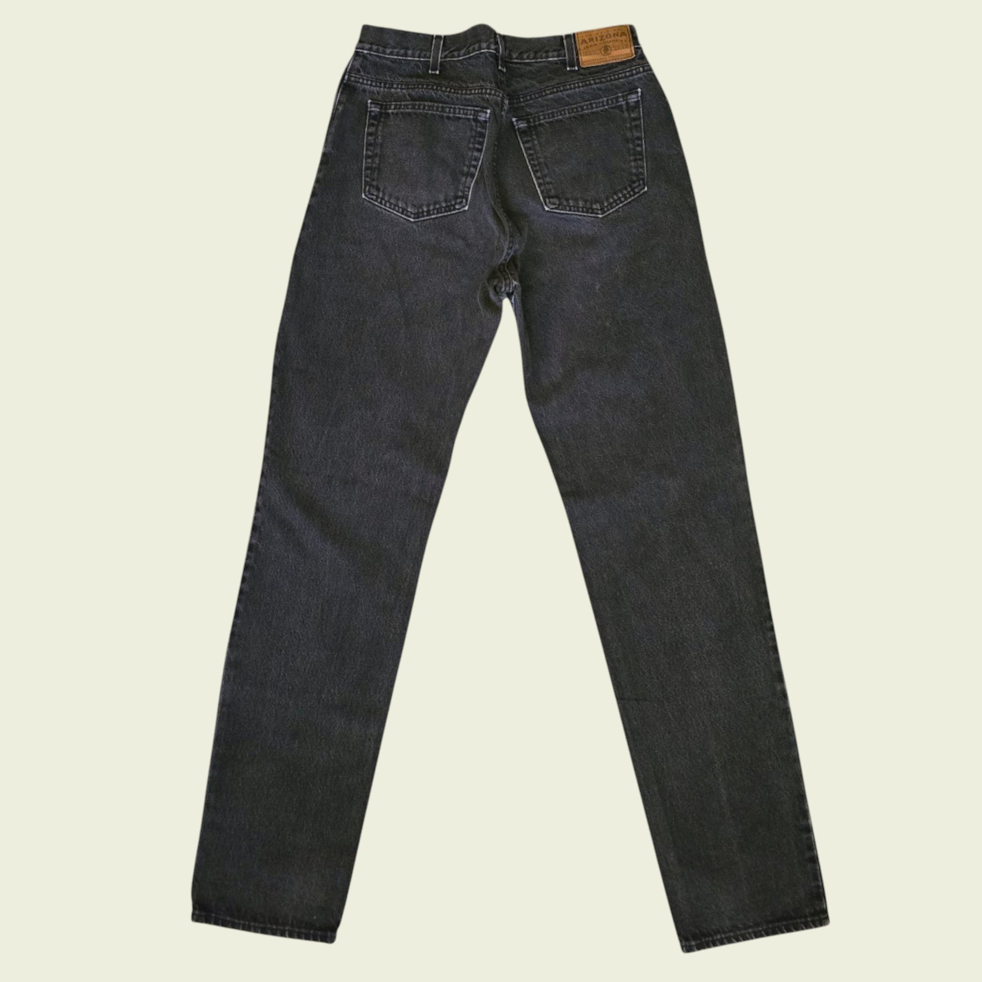 Pair of black jeans on a beige background