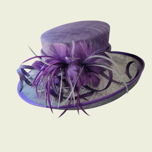 Mauve hat with feathers on beige background