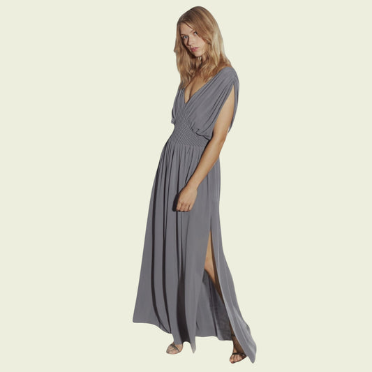Woman wearing a long gray dress on a beige background
