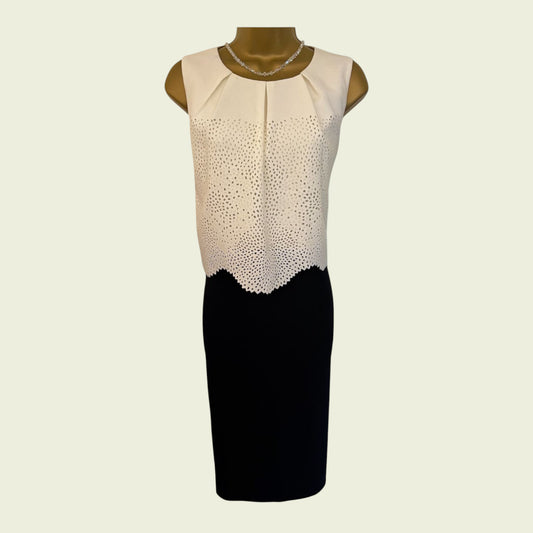 Mannequin wearing a dress with a cream top and black bottom on a light beige background