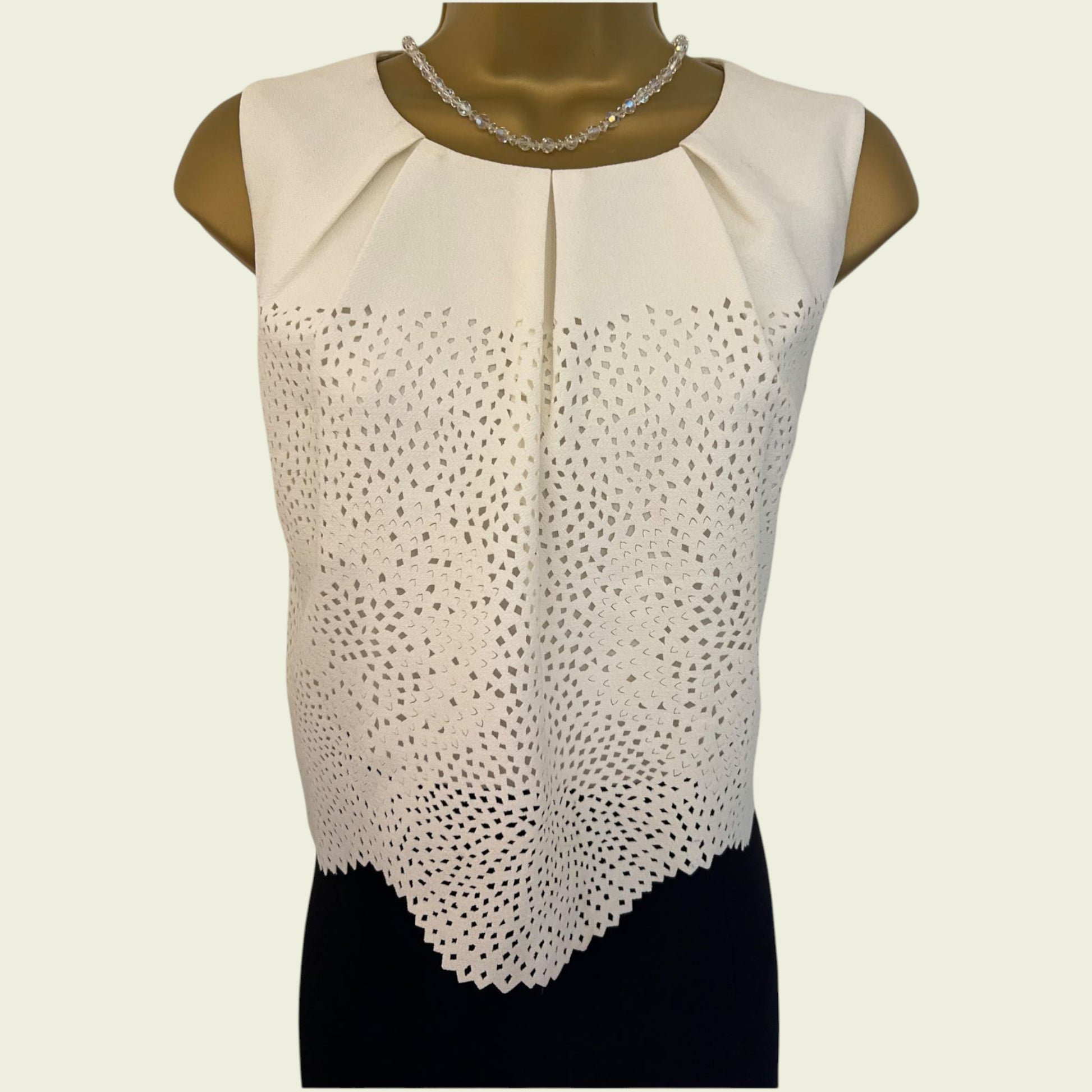 Black and cream sleeveless dress on a mannequin against a beige background