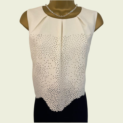 Black and cream sleeveless dress on a mannequin against a beige background