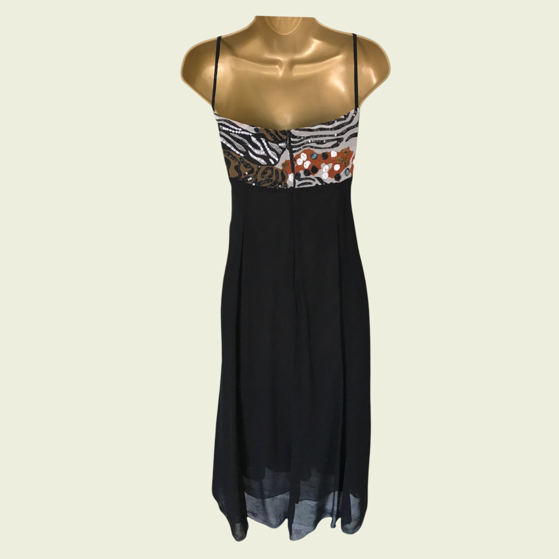 Black dress with zebra print and floral details on a mannequin against a beige background