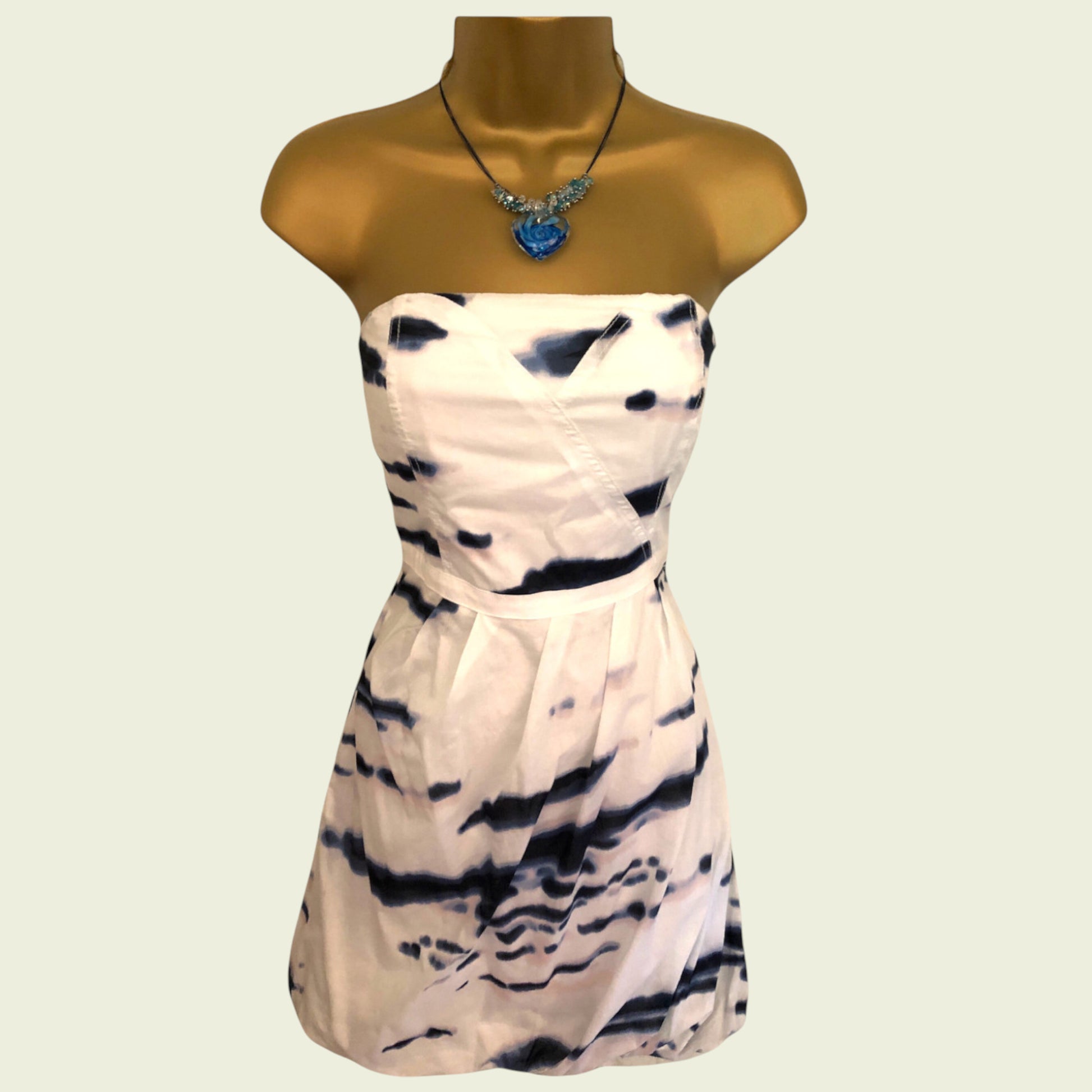 White strapless dress with black tie-dye pattern on a mannequin against a plain background