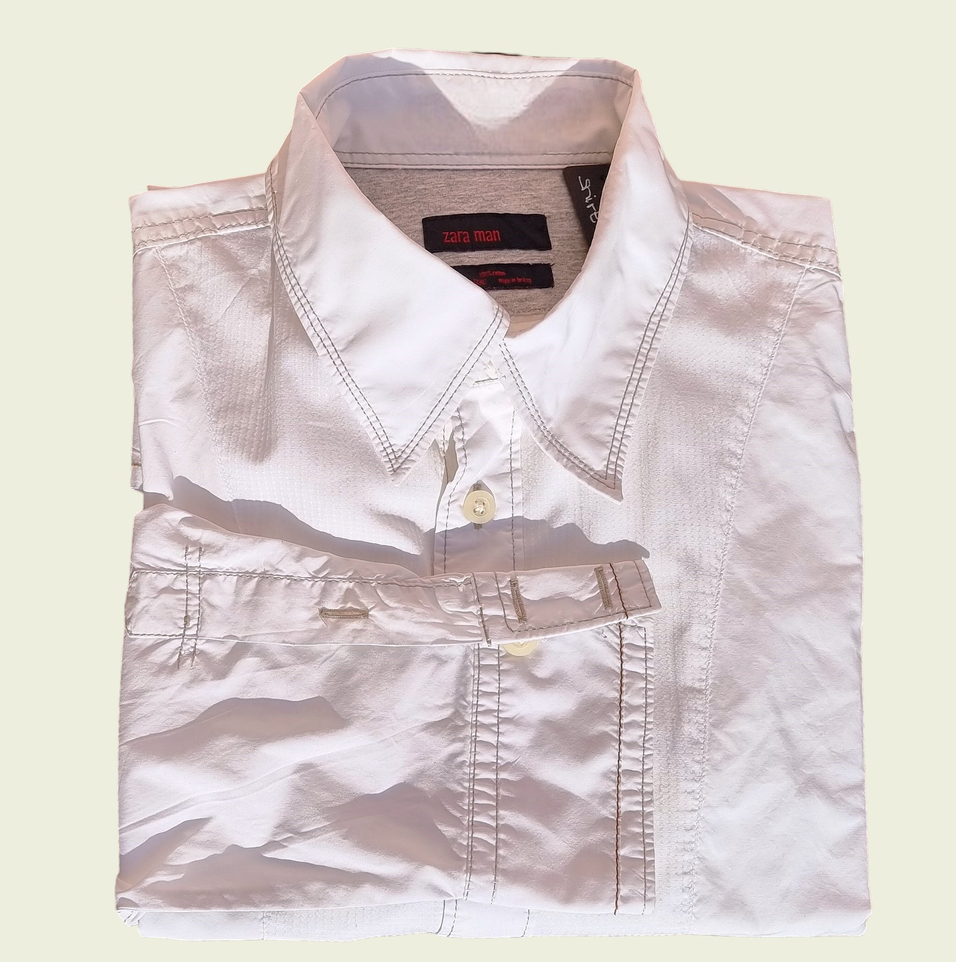 Men's white pleated dress shirt on beige background