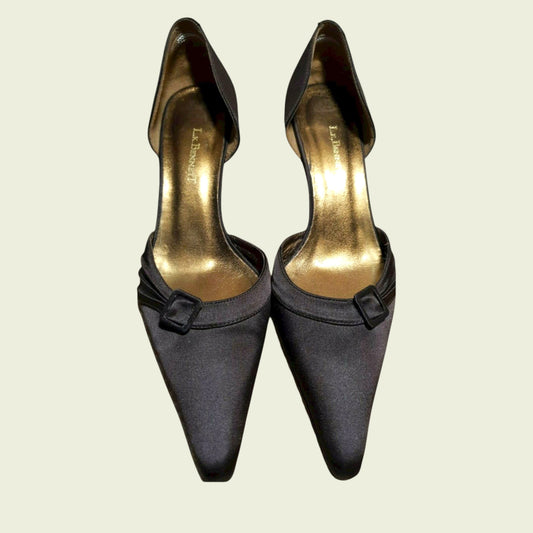 Pair of brown high-heeled shoes with gold soles on a beige background