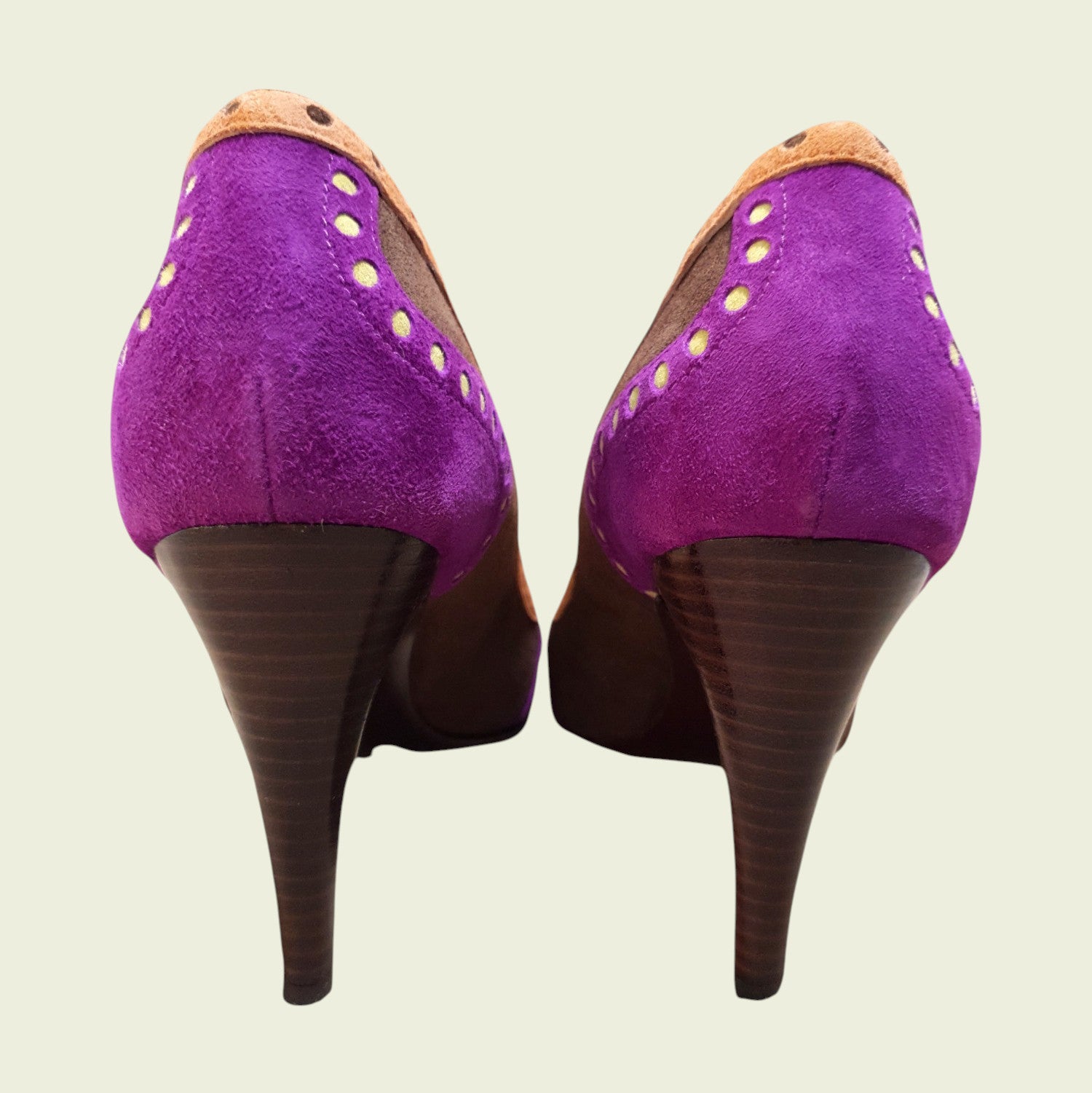 Purple high-heeled shoes with brown soles on a beige background