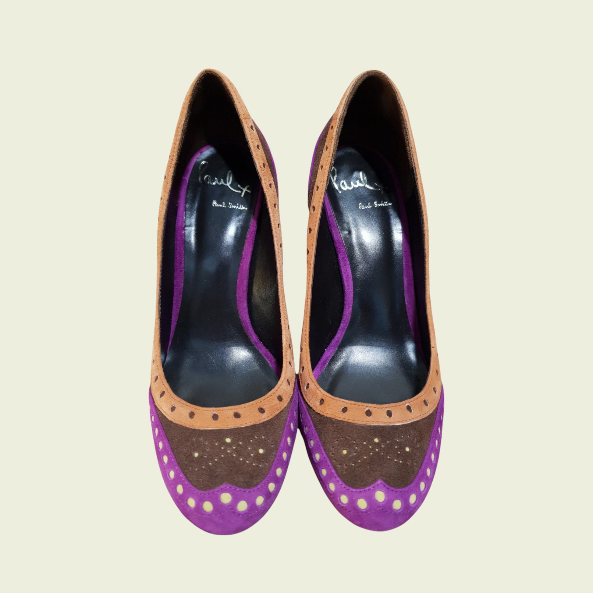 Pair of high-heeled shoes with purple and brown design on a beige background