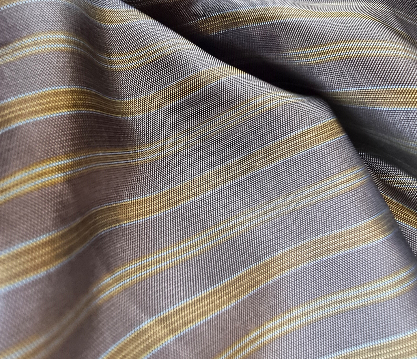 Close-up of striped fabric with brown, beige, and gray colors.