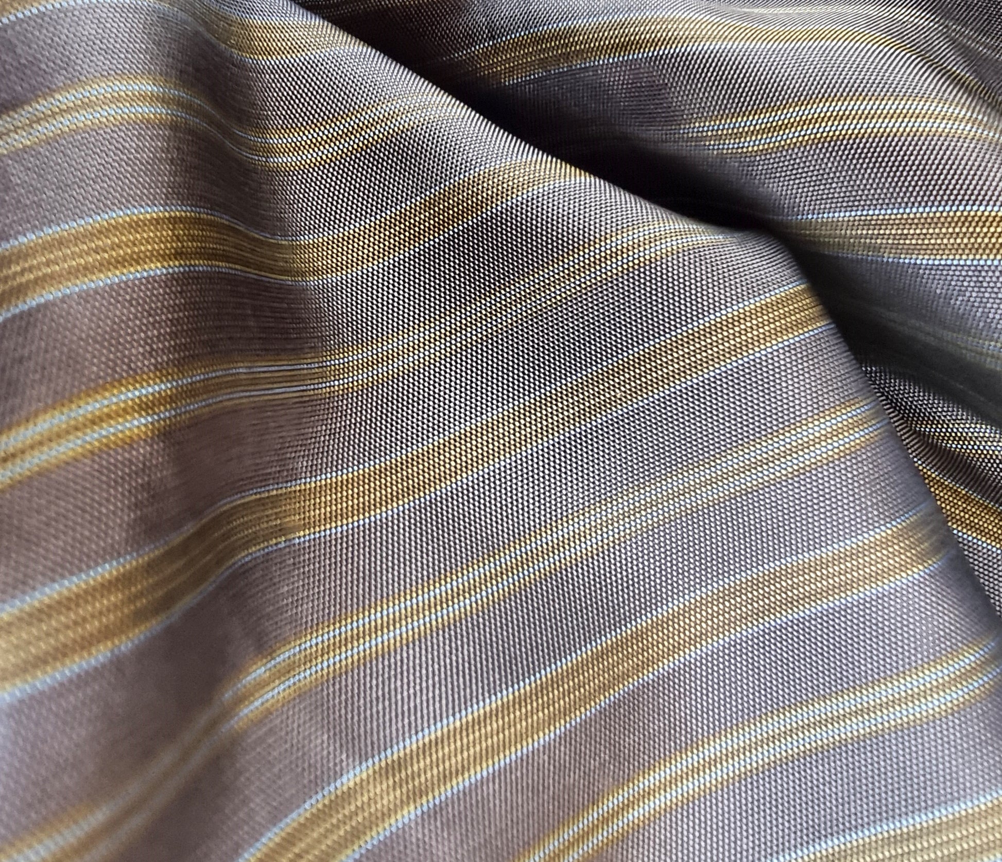 Close-up of striped fabric with brown, beige, and gray colors.