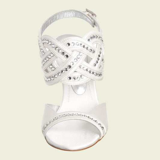 Silver high-heeled sandal with intricate design on a light beige background
