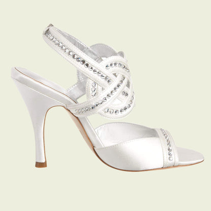 White high-heeled shoe with crystal embellishments on a light green background