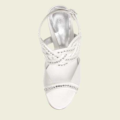 White sandal with embellishments on a light beige background