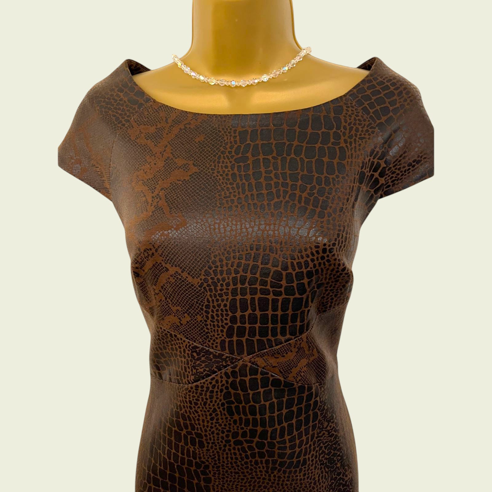 Brown textured dress on a mannequin with a plain background