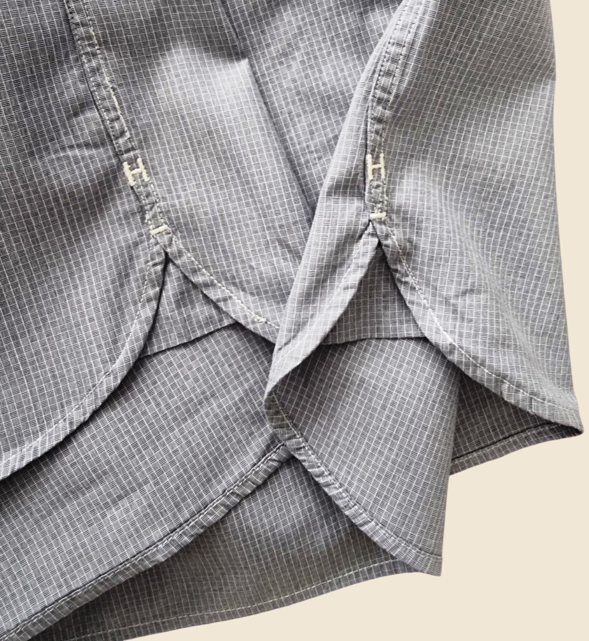 Close-up of a gray checkered shirt with a beige background
